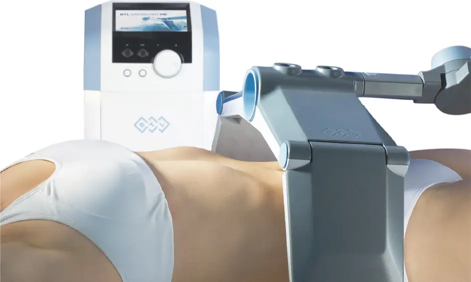 Person lying on a treatment table while a blue-and-white robotic device treats the abdomen area (medical procedure).